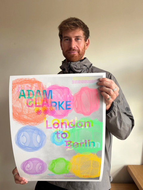 Adam holding his colourful London to Berlin cycling artwork